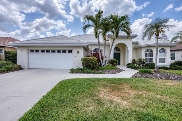 5106 Far Oak Cir, Sarasota, FL 34238 - view of front of home featuring a garage, stucco siding, a front yard, and concrete driveway