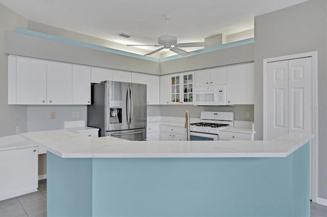 5106 Far Oak Cir, Sarasota, FL 34238 - kitchen with ceiling fan, white appliances, white cabinetry, and visible vents