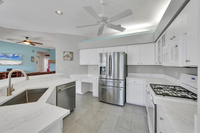 5106 Far Oak Cir, Sarasota, FL 34238 - kitchen with ceiling fan, a sink, light stone counters, white cabinets, and stainless steel appliances