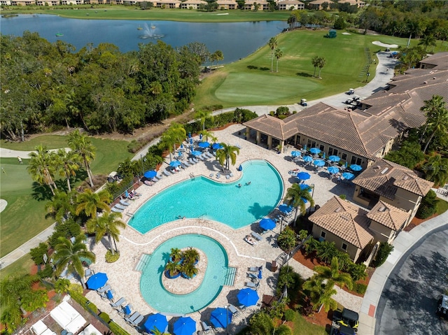drone / aerial view of a pool, a nearby body of water, and a golf club