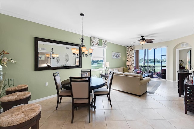 dining room featuring crown molding, a ceiling fan, a chandelier, light tile patterned floors, and baseboards