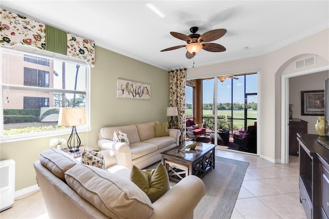 living room with a ceiling fan, light tile patterned floors, crown molding, and baseboards