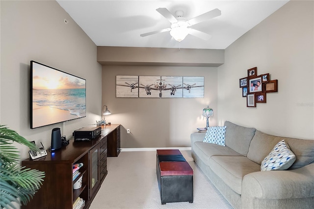 living room featuring light colored carpet, ceiling fan, and baseboards