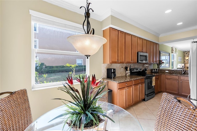 kitchen featuring stainless steel appliances, tasteful backsplash, dark stone countertops, brown cabinets, and crown molding