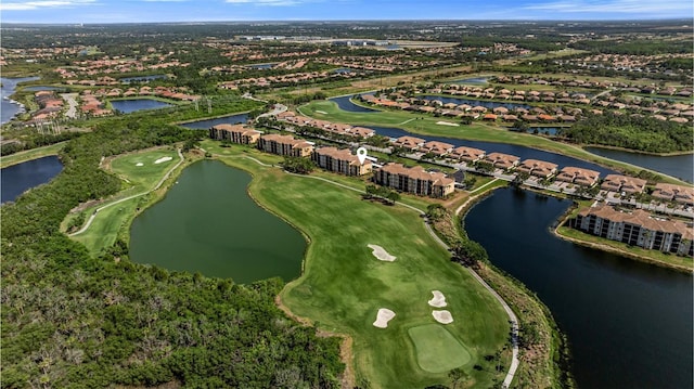 aerial view of property's location featuring a golf course, a nearby body of water, and nearby suburban area