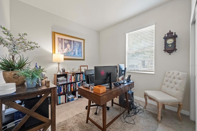 office featuring baseboards and light carpet