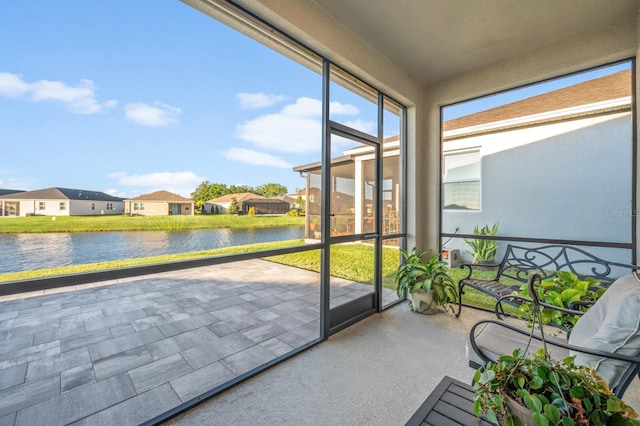 sunroom with a residential view and a water view