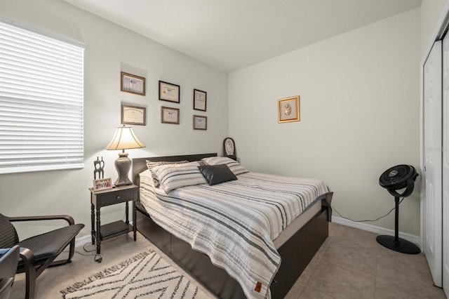 tiled bedroom with a closet and baseboards