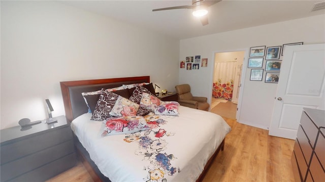 bedroom with ensuite bath, a ceiling fan, visible vents, and light wood-type flooring