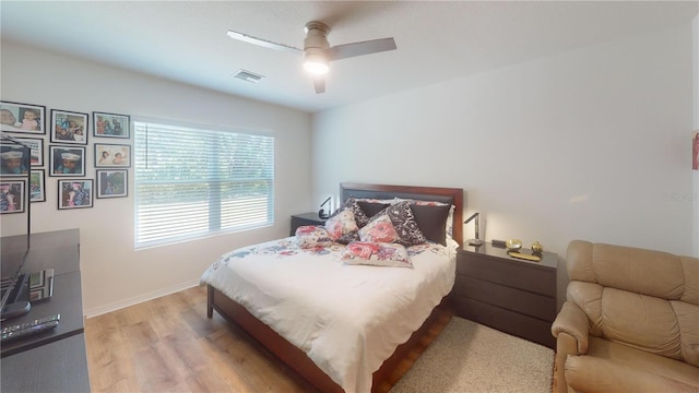 bedroom featuring baseboards, a ceiling fan, light wood-type flooring, and visible vents