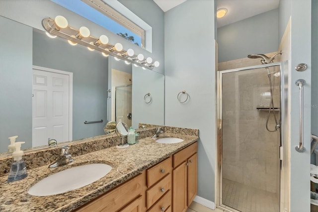 full bathroom with double vanity, a shower stall, and a sink
