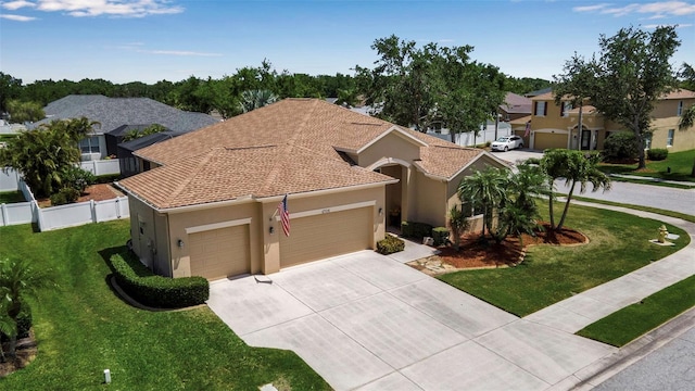 view of front of property with a front lawn, driveway, an attached garage, and stucco siding