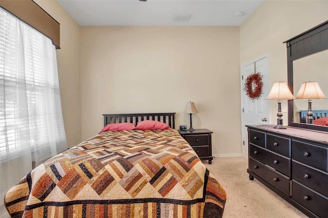bedroom with light colored carpet and baseboards