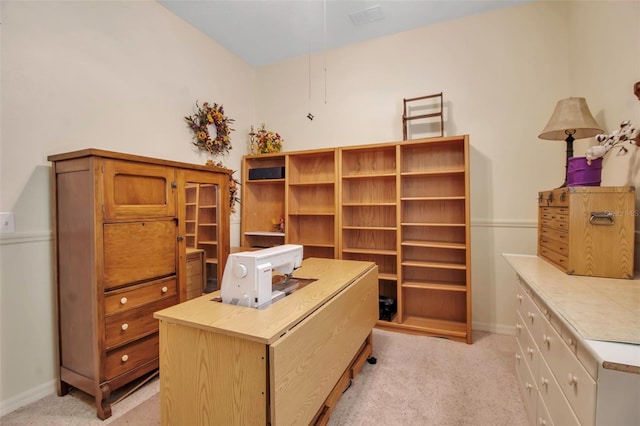 office area featuring baseboards and light carpet