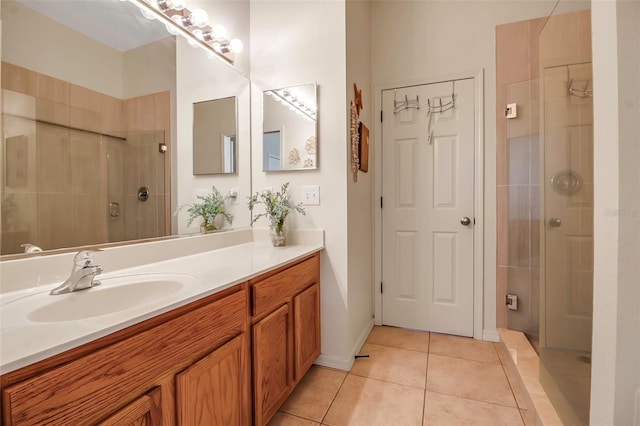 bathroom featuring tile patterned floors, an enclosed shower, and vanity