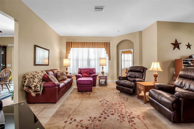 living room featuring visible vents, arched walkways, and light tile patterned flooring