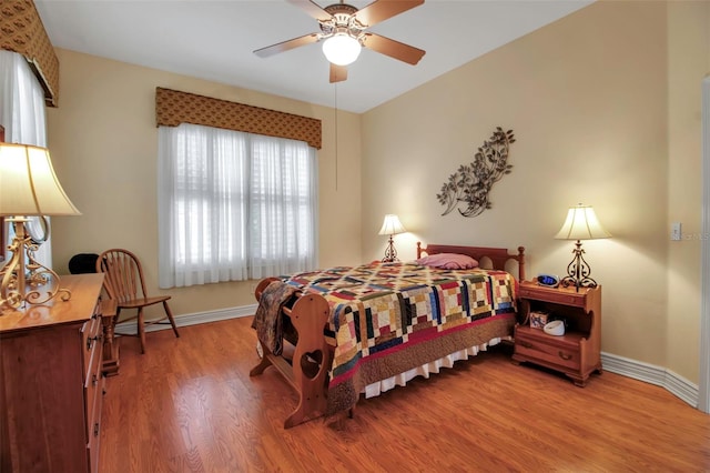 bedroom featuring wood finished floors, a ceiling fan, and baseboards