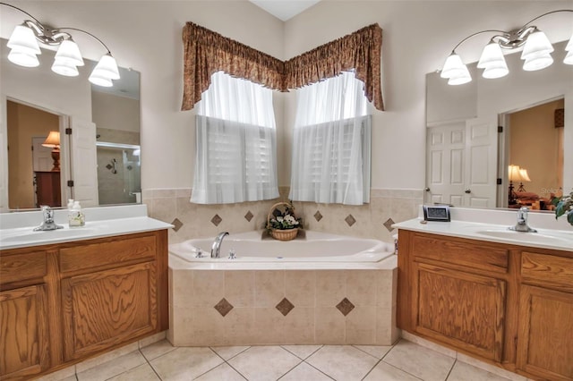 bathroom with a stall shower, a garden tub, tile patterned flooring, and a sink