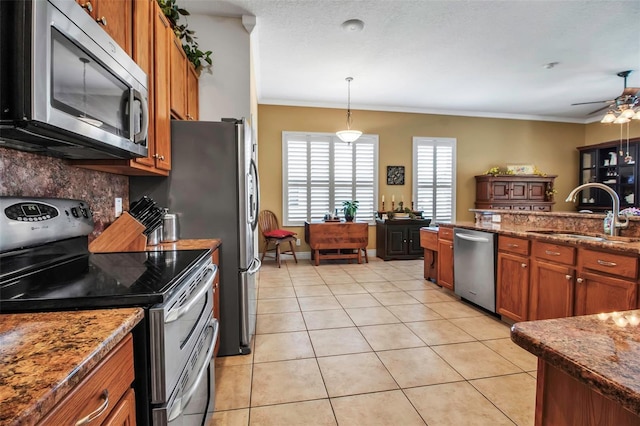 kitchen featuring a sink, brown cabinets, stainless steel appliances, crown molding, and backsplash
