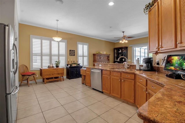 kitchen with light tile patterned floors, stainless steel appliances, a peninsula, and a sink