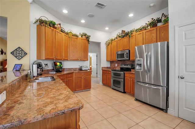 kitchen featuring decorative backsplash, light tile patterned floors, appliances with stainless steel finishes, a sink, and visible vents