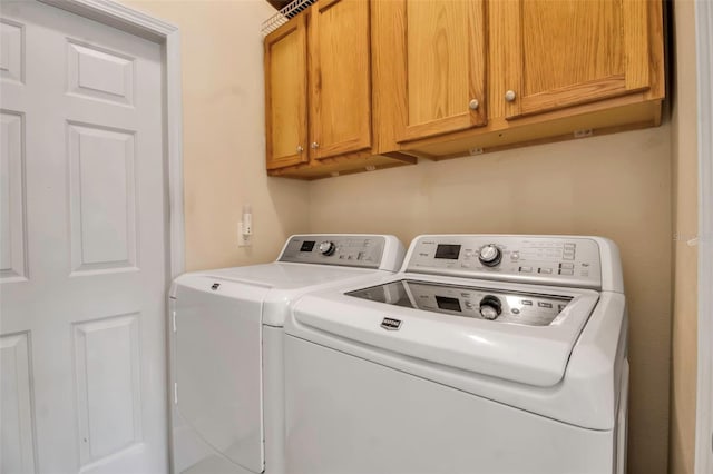 washroom featuring separate washer and dryer and cabinet space