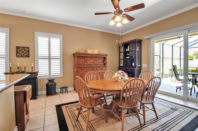 dining area featuring baseboards, light tile patterned floors, ceiling fan, and ornamental molding