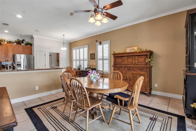 dining area featuring light tile patterned floors, a ceiling fan, ornamental molding, and baseboards