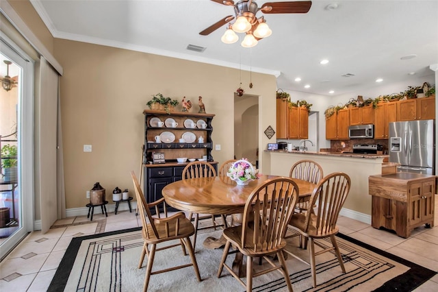 dining room with visible vents, light tile patterned floors, a ceiling fan, and crown molding