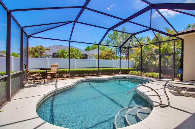 view of swimming pool with a patio, glass enclosure, a fenced in pool, and a fenced backyard