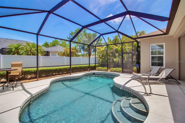 view of swimming pool featuring a patio, fence, glass enclosure, and a fenced in pool