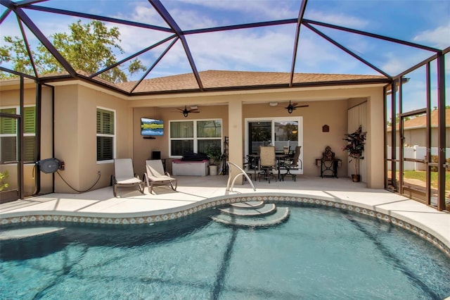 pool with outdoor dining space, glass enclosure, a ceiling fan, and a patio area