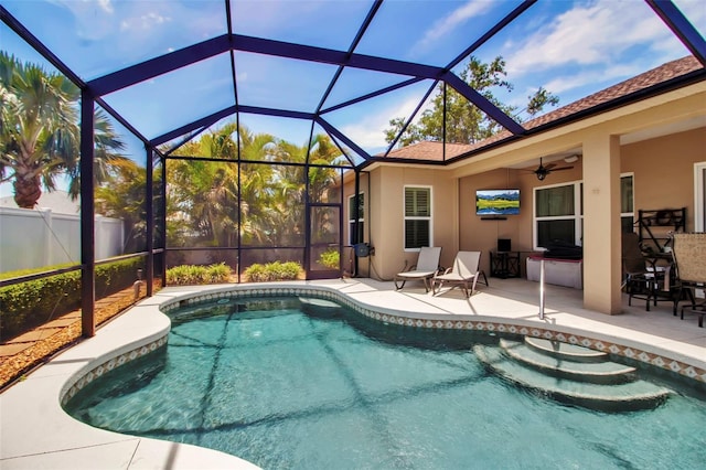 pool with a patio, ceiling fan, and glass enclosure