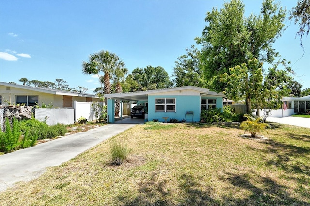 view of front facade featuring a front lawn, fence, driveway, and an attached carport
