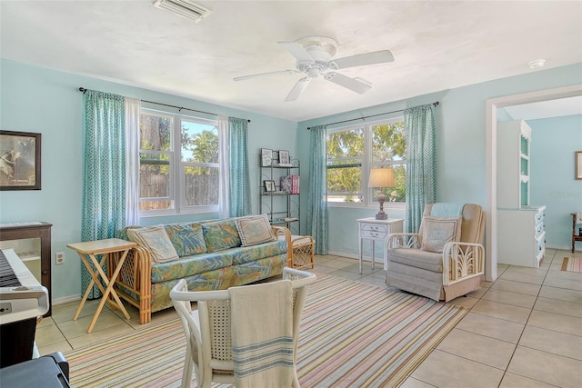 interior space with light tile patterned floors, baseboards, a ceiling fan, and visible vents