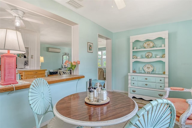 dining space with ceiling fan, a wall mounted AC, and visible vents