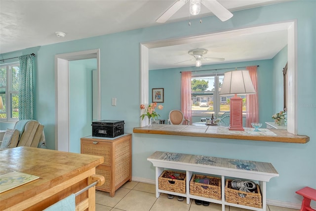 interior space with baseboards and a ceiling fan