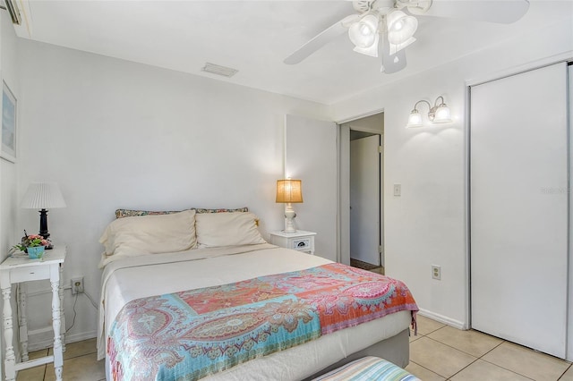 bedroom with a closet, visible vents, baseboards, ceiling fan, and light tile patterned floors