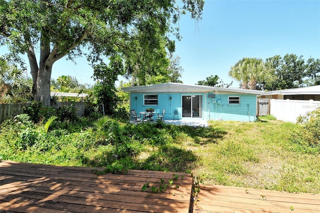 back of house with a wooden deck and a fenced backyard