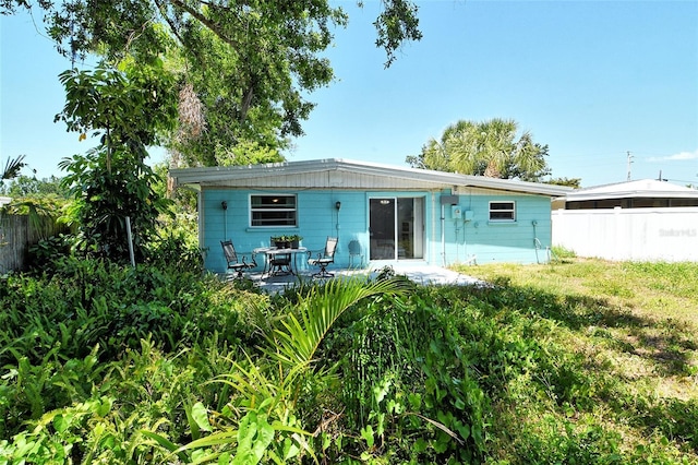 rear view of house featuring fence