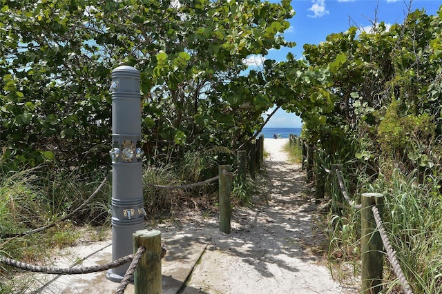 view of property's community with a water view and a view of the beach