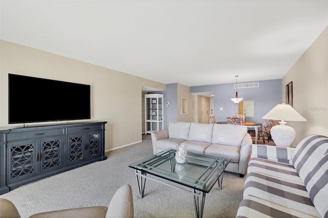 living area featuring baseboards, visible vents, and carpet flooring