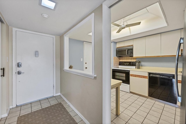 kitchen featuring tasteful backsplash, light tile patterned floors, light countertops, black appliances, and a ceiling fan