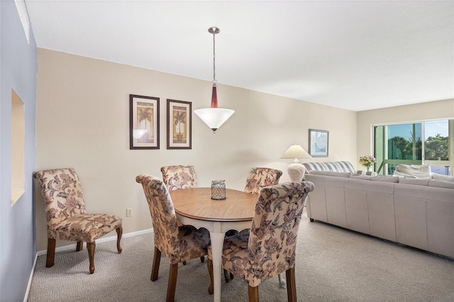 dining room featuring baseboards and light colored carpet