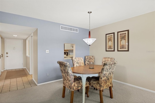 dining room featuring carpet flooring, visible vents, tile patterned floors, and baseboards