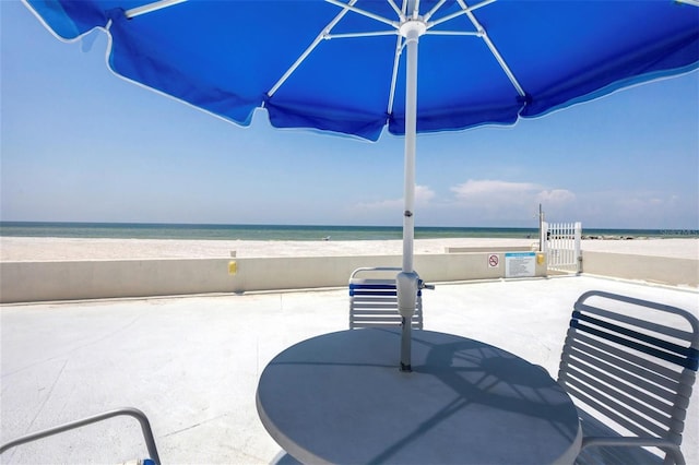 view of patio / terrace with a beach view and a water view