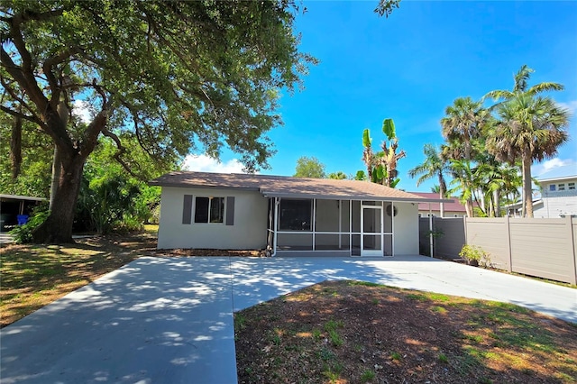 1722 Linhart Ave, Fort Myers, FL 33901 - rear view of house with a sunroom, stucco siding, and concrete driveway