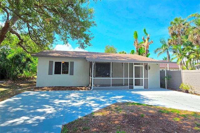 1722 Linhart Ave, Fort Myers, FL 33901 - rear view of house featuring stucco siding, a sunroom, a patio, and driveway