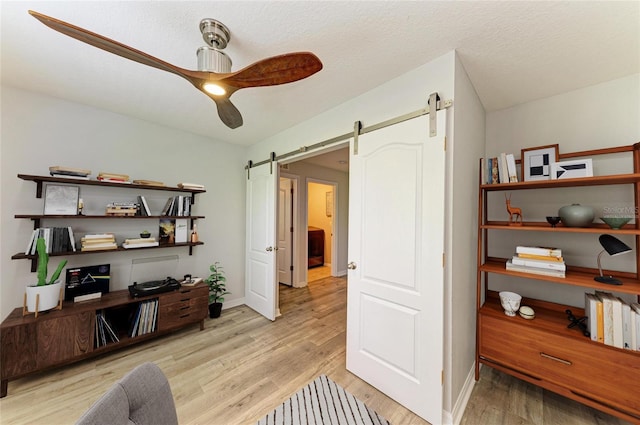 6125 35th Ct E, Bradenton, FL 34203 - office space with light wood-style floors, baseboards, a ceiling fan, and a barn door