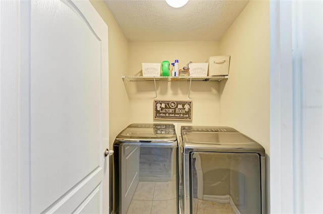 6125 35th Ct E, Bradenton, FL 34203 - clothes washing area with laundry area, a textured ceiling, light tile patterned floors, and washing machine and clothes dryer